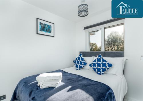 a bedroom with a bed with blue and white pillows at House with Garden & Private Driveway - Elite Properties in Leamington Spa