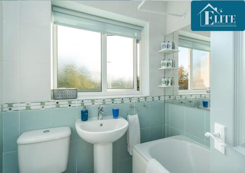 a bathroom with a white toilet and a sink at Semi - Detached House - Garden & Private Driveway - Elite Properties in Leamington Spa