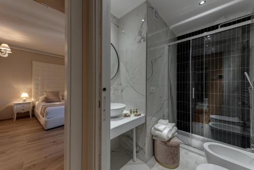 a bathroom with a shower and a sink and a mirror at PALAZZO DEL CAPITANO Wellness & Relais - Luxury Borgo Capitano Collection in San Quirico dʼOrcia