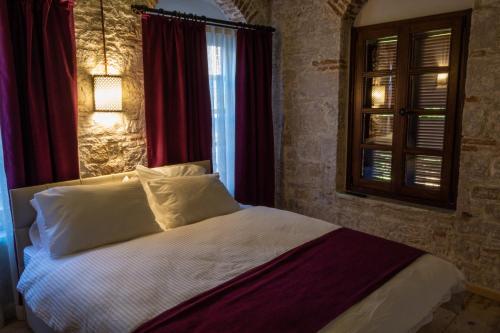 a bedroom with a large bed with a window at Olea Leya in Ayvalık