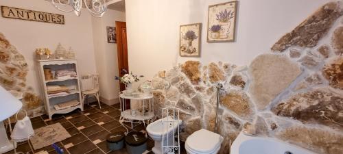 a bathroom with two toilets and a stone wall at Dolce shabby in Modica