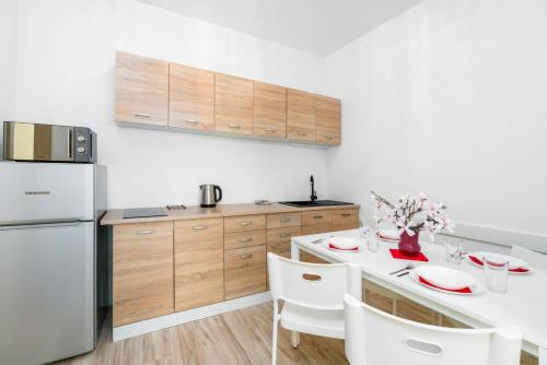 uma cozinha com uma mesa branca e um frigorífico branco em Apartment and Rooms at Mostowa street em Poznań