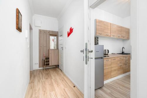uma cozinha com paredes brancas e um frigorífico em Apartment and Rooms at Mostowa street em Poznań