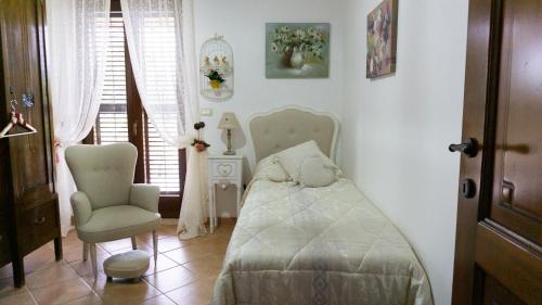 a bedroom with a bed and a chair at Dolce shabby in Modica