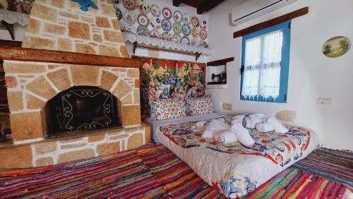 Archontiko Stegna في أرخانجلوس: غرفة نوم بها موقد وسرير في غرفة