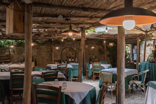 a restaurant with tables and chairs in a room at PALAZZO DEL CAPITANO Wellness & Relais - Luxury Borgo Capitano Collection in San Quirico dʼOrcia