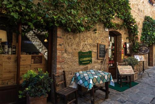 a stone building with two chairs and a table at PALAZZO DEL CAPITANO Wellness & Relais - Luxury Borgo Capitano Collection in San Quirico dʼOrcia