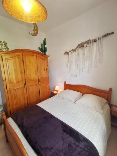 a bedroom with a large bed with a wooden headboard at Caseta de pescadors a les cales de Colera, 2ª linea de mar in Colera
