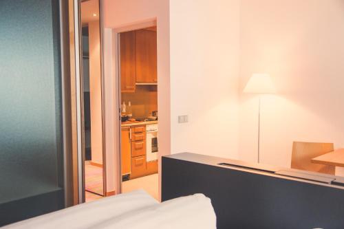 a room with a bed and a kitchen at Quality Hosts Arlberg - Hotel ANTON in Sankt Anton am Arlberg