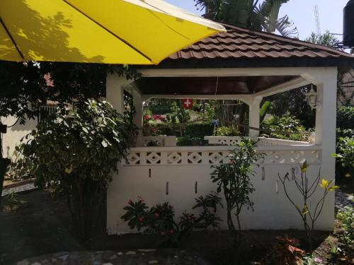 a white gazebo with a yellow umbrella at Swiss Garden House in Kerr Sering With Full Private Compound in Amdalai