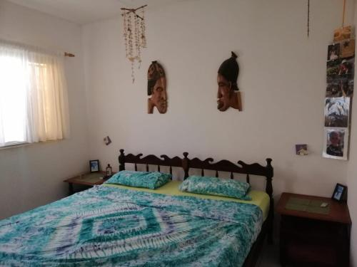 a bedroom with a bed and two pictures on the wall at Swiss Garden House in Kerr Sering With Full Private Compound in Amdalai