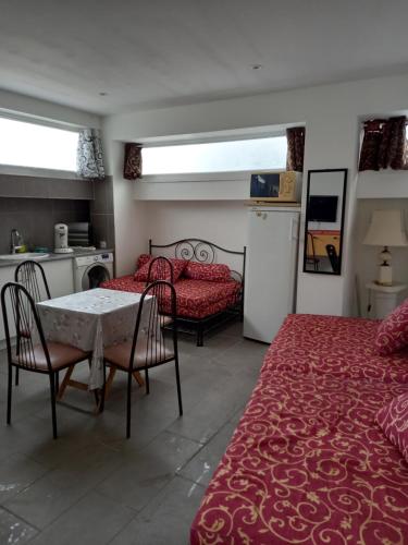 een slaapkamer met 2 bedden, een tafel en een keuken bij Maison à contes in Contes
