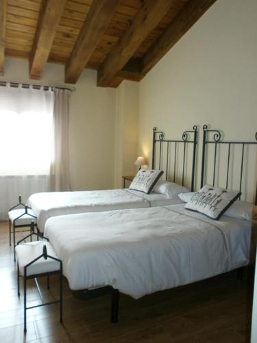 two twin beds in a room with a window at Casa Rural El Alcarcel in Santo Domingo de Pirón