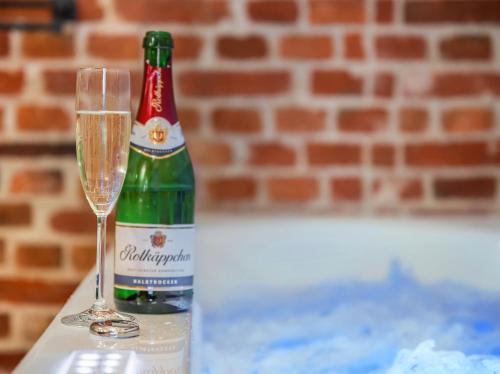 a bottle of champagne and a glass on a table at Speicher Hafendomizil in Barth