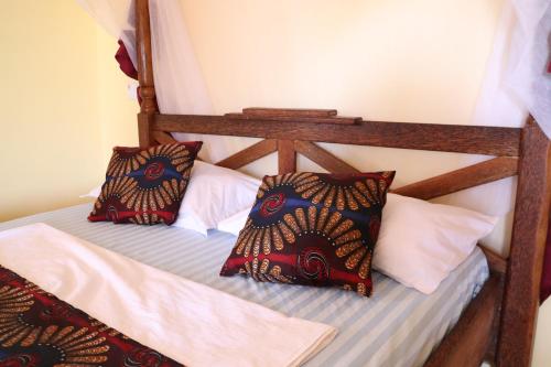 a wooden bunk bed with pillows on it at Tipitipi house in Kizimkazi