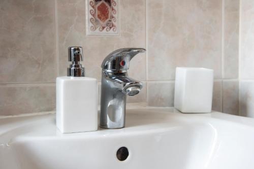 - un lavabo avec un robinet et 2 serviettes en papier dans l'établissement Holyrood Park Main Door Apartment, à Édimbourg
