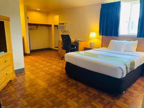 a hotel room with a large bed and a desk at America's Best Value Inn Sandpoint in Sandpoint