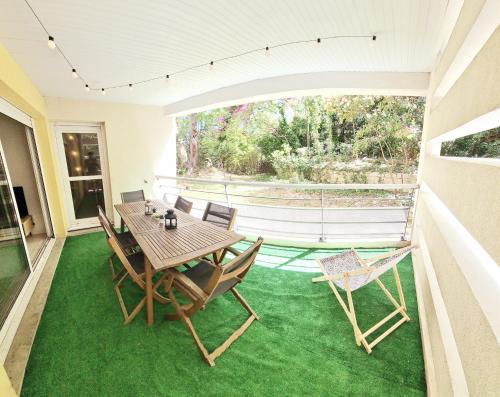 - une terrasse avec une table et des chaises sur un sol verdoyant dans l'établissement 