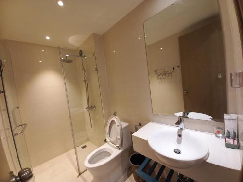 een badkamer met toilet, wastafel en douche bij Angela House Ha Long in Ha Long