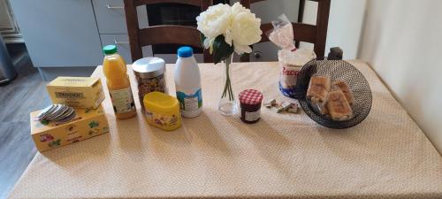 une table avec un vase de fleurs et de médicaments dans l'établissement Nuits au Grenier de Chartres, à Chartres