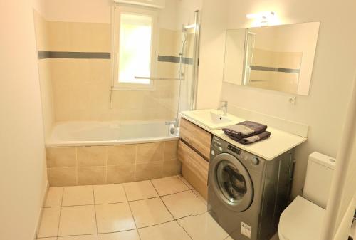 La salle de bains est pourvue d'un lave-linge et d'une baignoire. dans l'établissement 