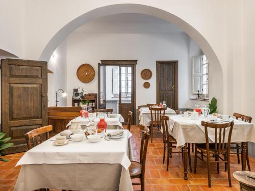 a dining room with tables and chairs with white tablecloths at PALAZZO CHERCHI in Dorgali