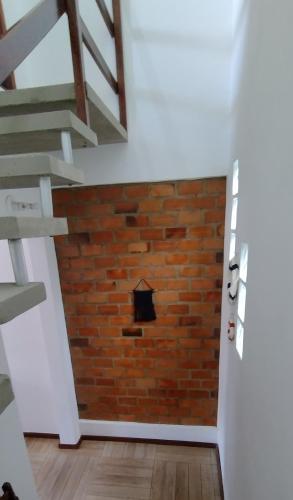 a brick wall in a room with a staircase at Saquaflats in Saquarema