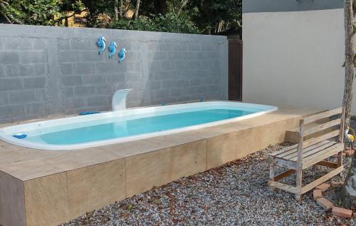 a bath tub sitting next to a stone wall at Saquaflats in Saquarema