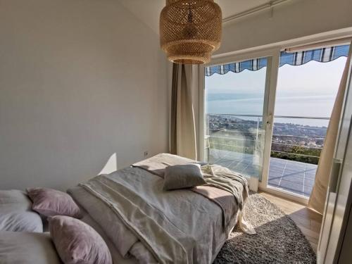 a bedroom with a bed and a large window at Ferienwohnung mit 180° Meerblick (nähe Opatija) in Dobreć