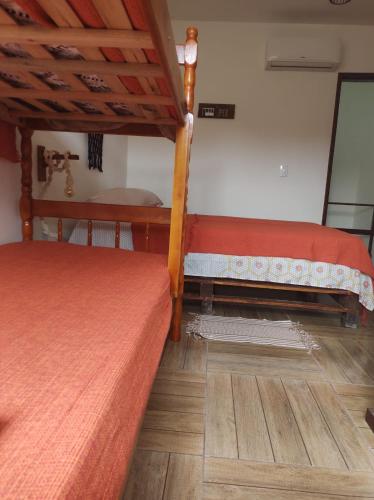 a bedroom with two bunk beds and a wooden floor at Saquaflats in Saquarema
