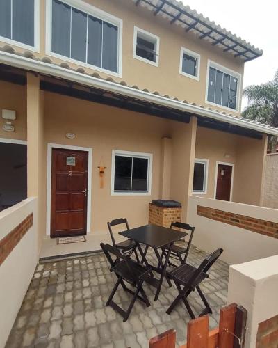 a patio with a table and chairs in front of a house at Saquaflats in Saquarema