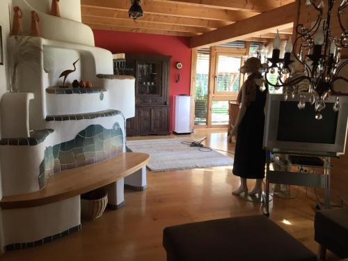 a woman standing in a living room with a television at Wein-Chalet W141 in Weinburg am Saßbach