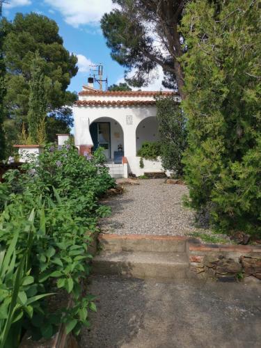 a white house with a pathway leading to it at Caseta de pescadors a les cales de Colera, 2ª linea de mar in Colera