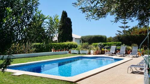a swimming pool in a yard with two lawn chairs at VILLA BINISABEL NOU, CONFORT Y EXCLUSIVIDAD in Sant Lluis