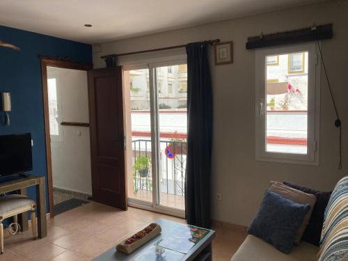 a living room with a couch and a sliding glass door at ApartaUnMomento y Disfruta!! in Estepona
