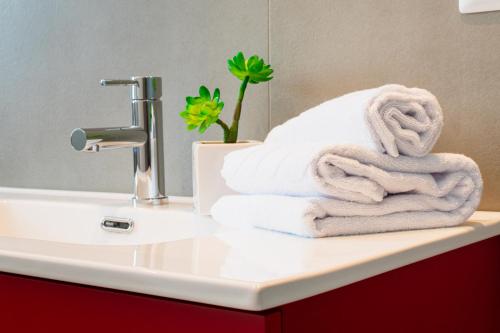 a pile of towels sitting on top of a bathroom sink at Superior Beach Aparthotel in Lido di Jesolo