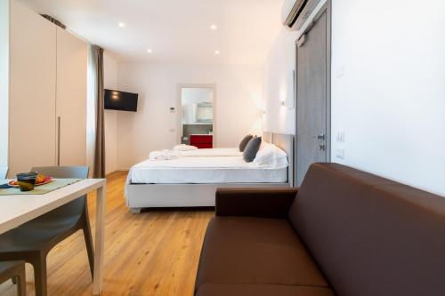 a living room with a bed and a couch at Superior Beach Aparthotel in Lido di Jesolo