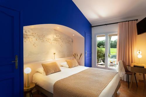 une chambre bleue avec un lit et une fenêtre dans l'établissement San Giovanni, à Porto-Vecchio