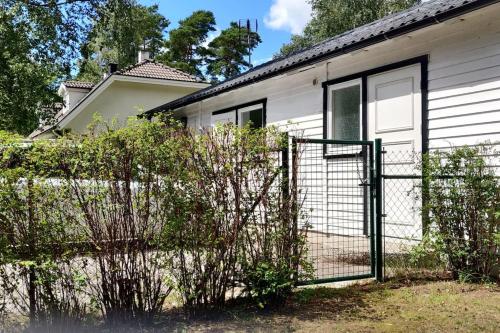 a fence in front of a white house at On your way in Löddeköpinge