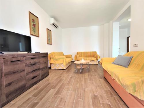 a living room with a bed and a flat screen tv at Apartments Morena in Rakalj