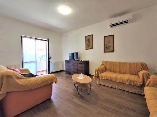 a living room with two couches and a table at Apartments Morena in Rakalj