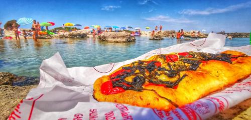 a pizza sitting on a table at the beach at Casina Raho B&B in Nardò