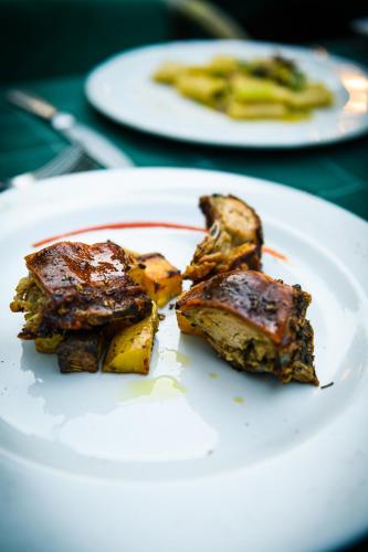 a white plate with some food on a table at PALAZZO DEL CAPITANO Wellness & Relais - Luxury Borgo Capitano Collection in San Quirico dʼOrcia