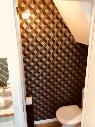 a bathroom with a toilet and a tiled wall at • CosyHouse By Janna • Terrasse - Wifi in Châtellerault