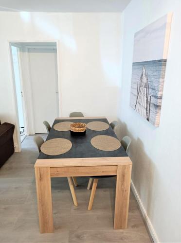 a wooden table with a bowl of food on top at Appartement refait à neuf résidence avec piscine Trouville sur mer in Trouville-sur-Mer