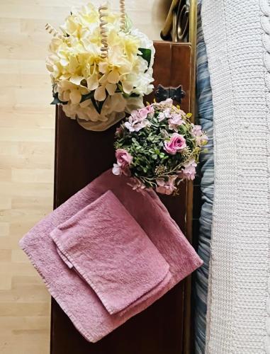two baskets of flowers and a towel next to a bed at Da Benedetta in Cantagrillo