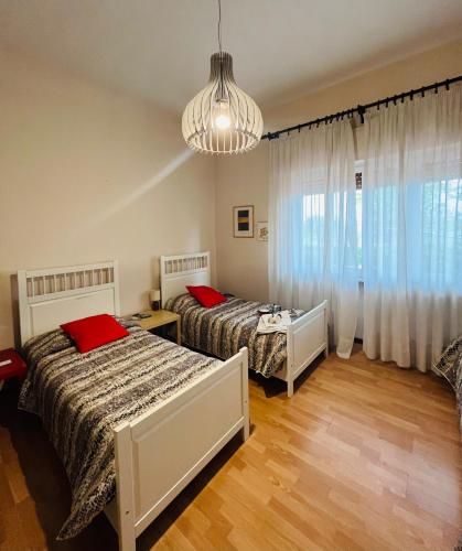 a bedroom with two beds and a chandelier at Da Benedetta in Cantagrillo
