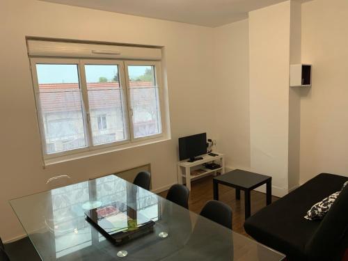 a living room with a glass table and a couch at Logement, idéal famille, amis, tout y est ! in Dompierre-sur-Besbre
