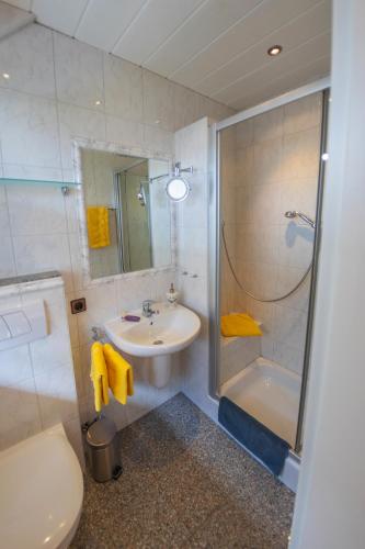 a bathroom with a sink and a toilet and a shower at Gästehaus Heidi in Kröv