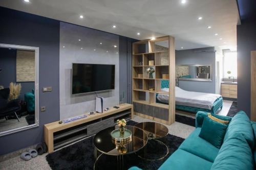 sala de estar con sofá azul y cama en LP Apartments, en Tuzla